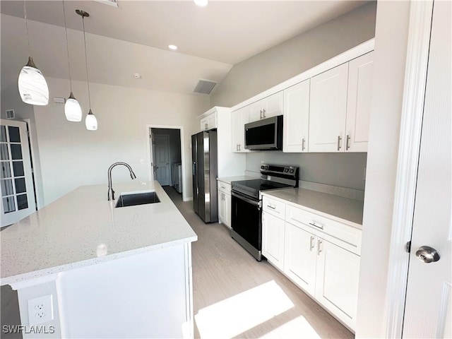 kitchen with lofted ceiling, sink, appliances with stainless steel finishes, decorative light fixtures, and white cabinetry