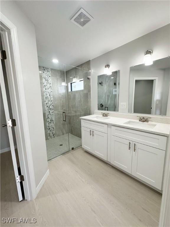 bathroom with vanity, wood-type flooring, and walk in shower