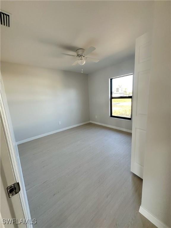 spare room with ceiling fan and wood-type flooring