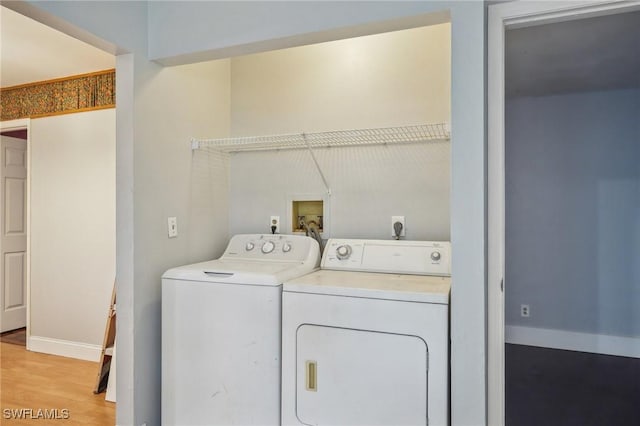 laundry room featuring separate washer and dryer and light wood-type flooring