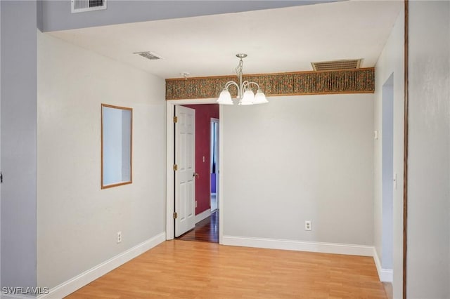 unfurnished dining area with hardwood / wood-style flooring and an inviting chandelier