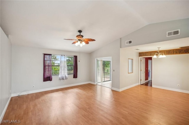 unfurnished room with vaulted ceiling, wood-type flooring, and ceiling fan with notable chandelier