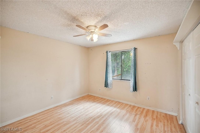 empty room featuring a textured ceiling, light hardwood / wood-style flooring, and ceiling fan