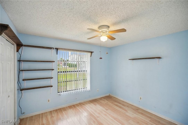 empty room featuring a textured ceiling, light hardwood / wood-style flooring, and ceiling fan