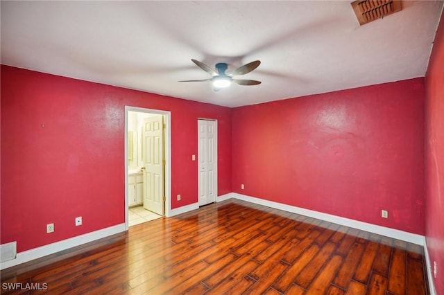 unfurnished bedroom with ensuite bath, ceiling fan, and hardwood / wood-style flooring