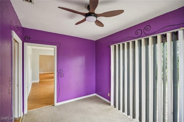 carpeted spare room with ceiling fan