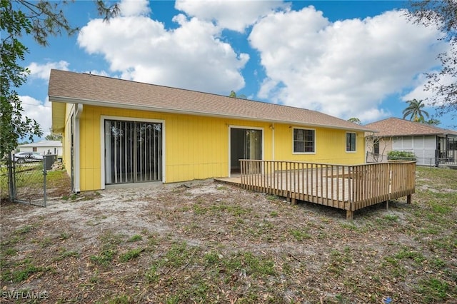 rear view of house featuring a wooden deck