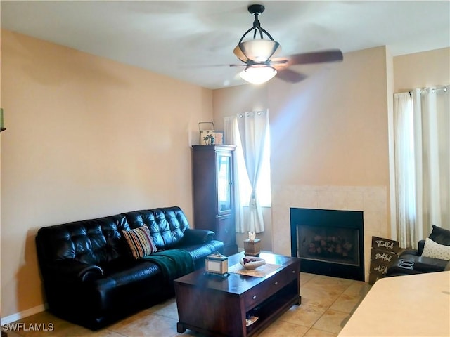 living room with ceiling fan, light tile patterned floors, and a tile fireplace