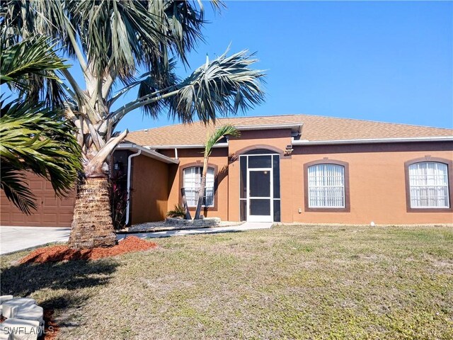 rear view of property featuring a lawn and a garage