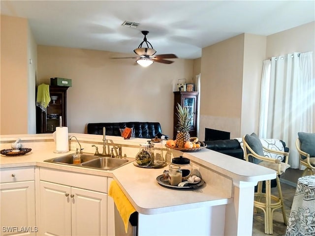 kitchen with ceiling fan, sink, white cabinets, and tile patterned flooring