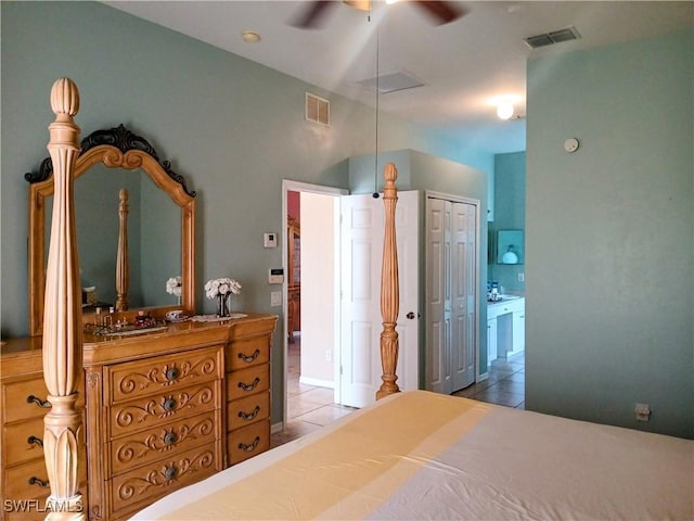 tiled bedroom with ceiling fan, ensuite bathroom, and a closet