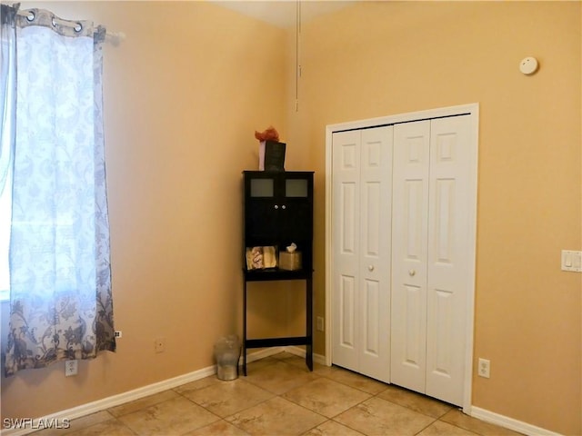 unfurnished bedroom featuring a closet and light tile patterned floors