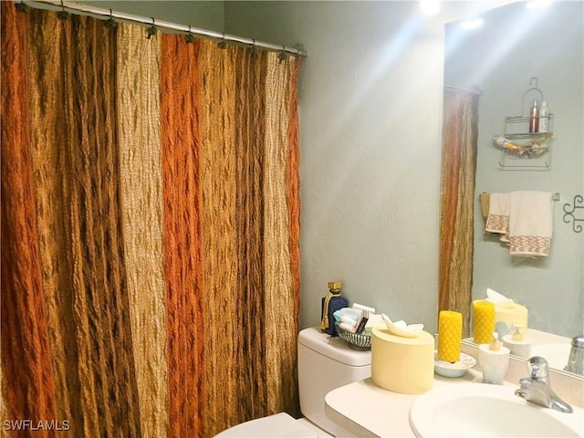 bathroom with a shower with shower curtain, vanity, and toilet