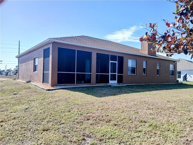 back of property with a sunroom and a yard