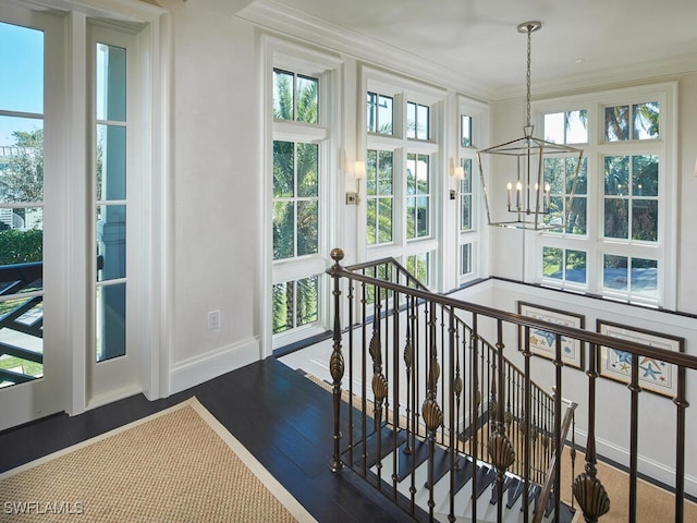 stairway with a chandelier, hardwood / wood-style flooring, and crown molding