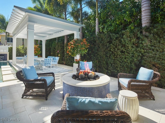 view of patio with a pergola and an outdoor living space with a fire pit