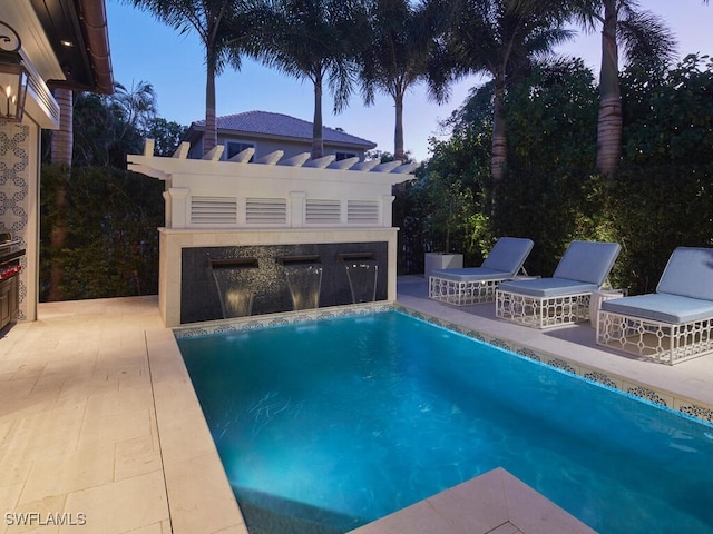 pool at dusk with a patio area and an outdoor fireplace