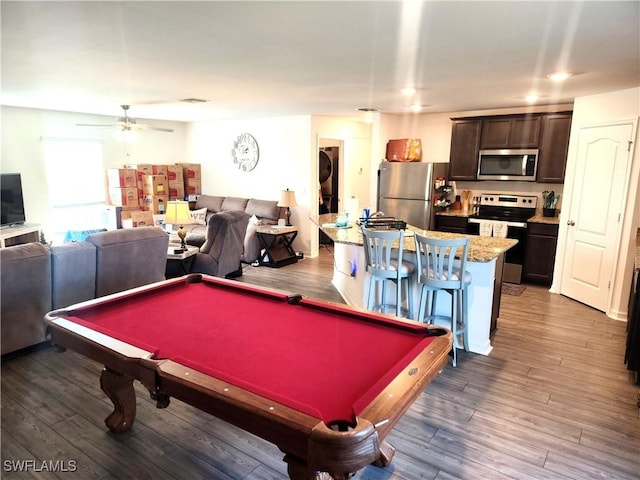 playroom with dark hardwood / wood-style flooring, stacked washing maching and dryer, ceiling fan, and pool table