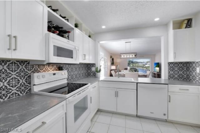 kitchen featuring white cabinetry, sink, hanging light fixtures, white appliances, and decorative backsplash