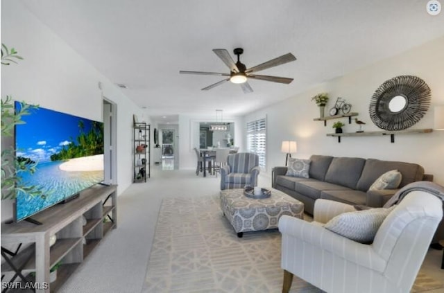 carpeted living room with ceiling fan