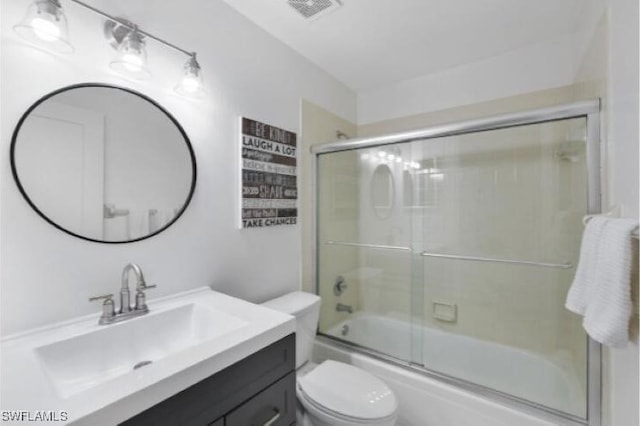 full bathroom featuring vanity, toilet, and shower / bath combination with glass door