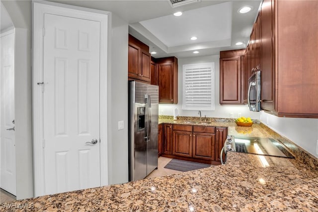 kitchen with sink, stainless steel appliances, and a tray ceiling