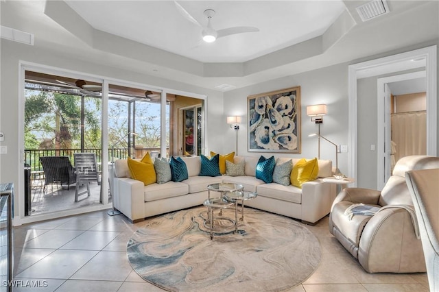 living room featuring light tile patterned floors and a tray ceiling