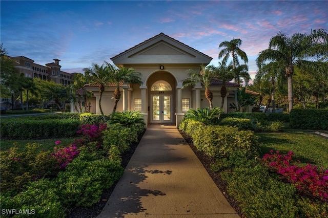 exterior entry at dusk featuring french doors