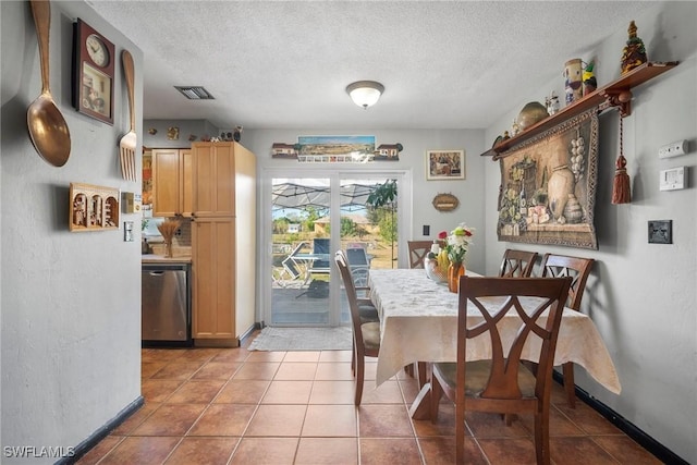 dining space with light tile patterned floors and a textured ceiling