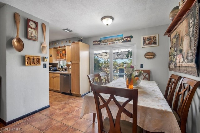 tiled dining space featuring a textured ceiling and sink