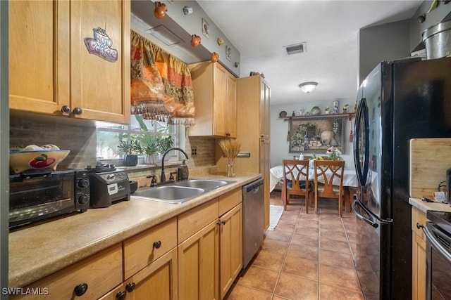 kitchen featuring backsplash, black fridge, sink, stainless steel dishwasher, and light tile patterned floors