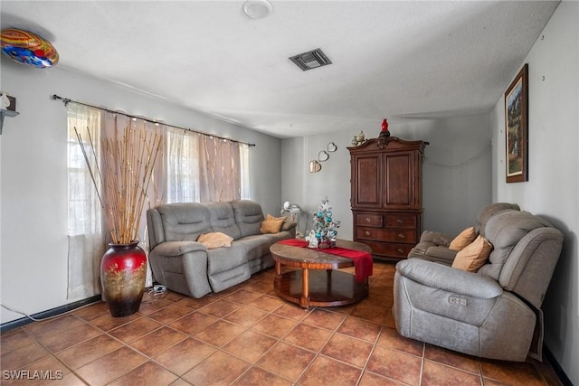 tiled living room featuring a textured ceiling