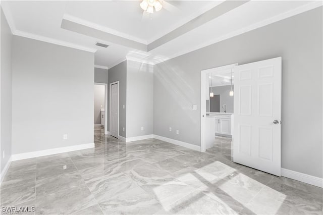 spare room with a raised ceiling, ceiling fan, sink, and ornamental molding