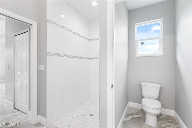 bathroom featuring toilet and tiled shower