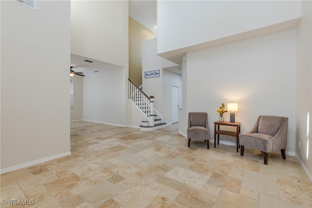 living area with a high ceiling and ceiling fan