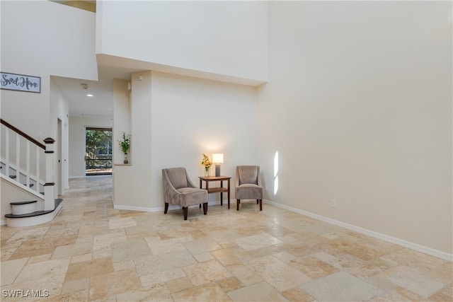 living area with a towering ceiling