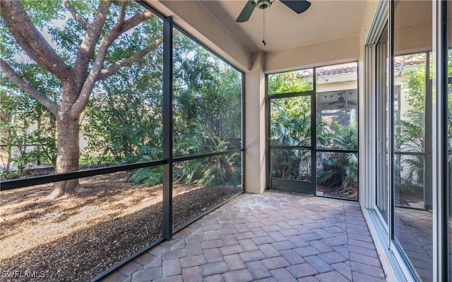 unfurnished sunroom with ceiling fan