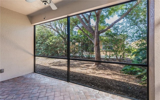 unfurnished sunroom featuring ceiling fan