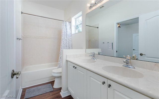 full bathroom featuring vanity, hardwood / wood-style flooring, shower / bathtub combination with curtain, and toilet