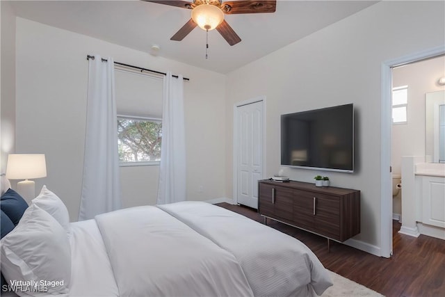 bedroom featuring connected bathroom, dark wood-type flooring, a closet, and ceiling fan