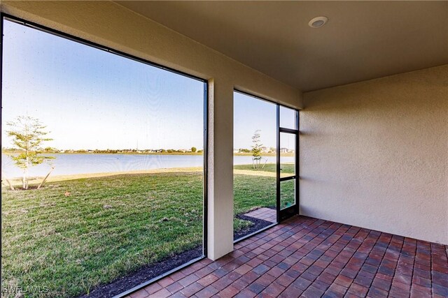 unfurnished sunroom featuring a water view