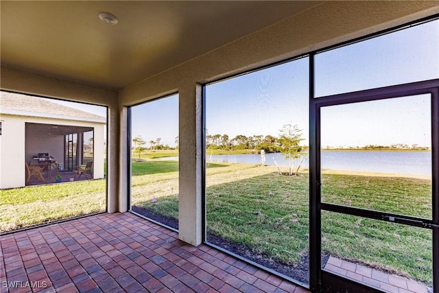 unfurnished sunroom with a water view