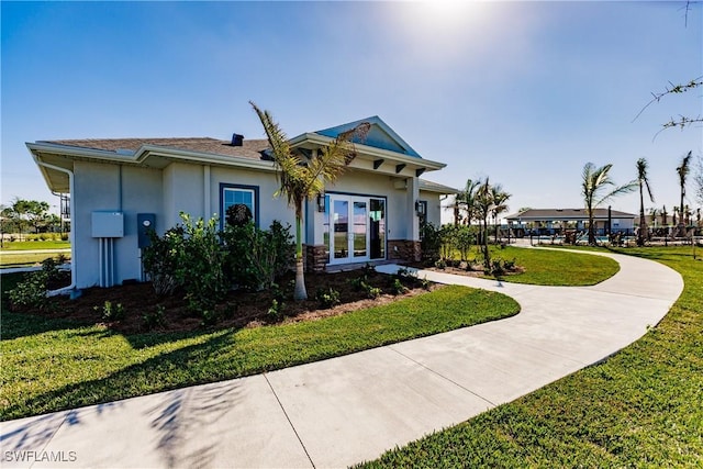 view of front of house featuring a front yard and french doors