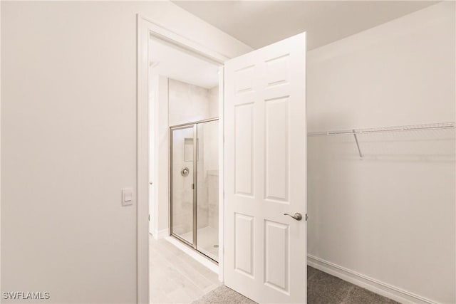 bathroom featuring a shower with door