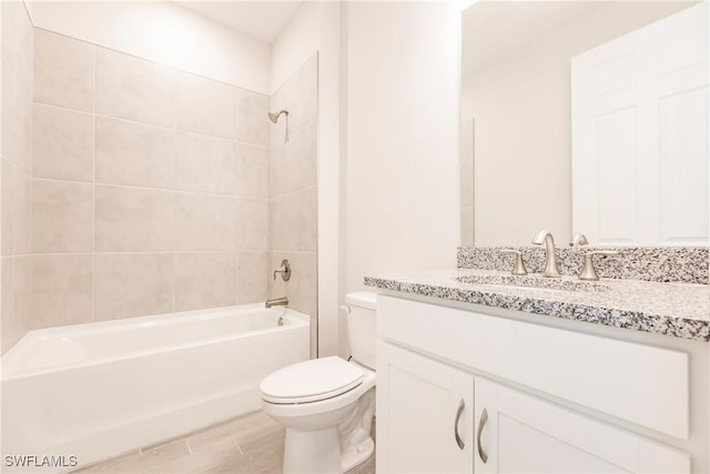 full bathroom featuring toilet, vanity, and tiled shower / bath