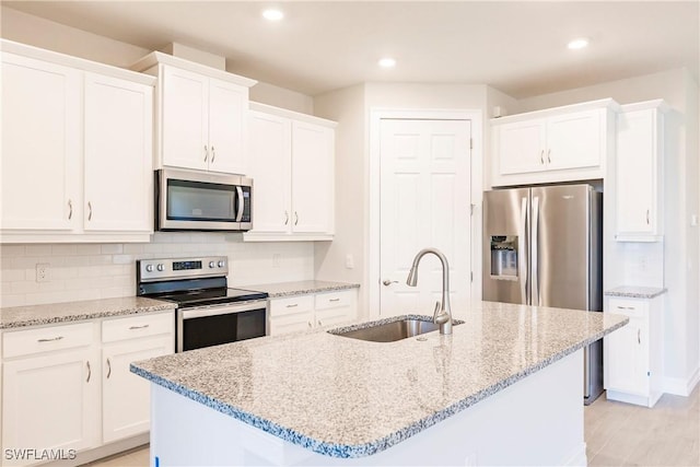 kitchen featuring white cabinetry, a center island with sink, stainless steel appliances, and sink