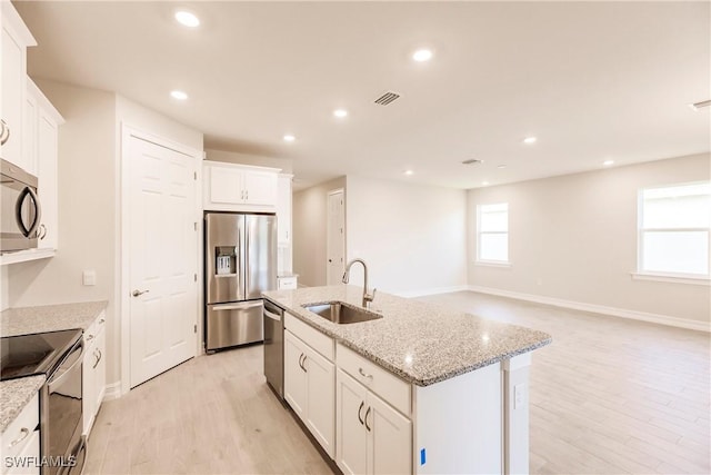 kitchen with a center island with sink, sink, white cabinetry, and stainless steel appliances