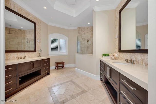 bathroom featuring a tile shower, vanity, and crown molding