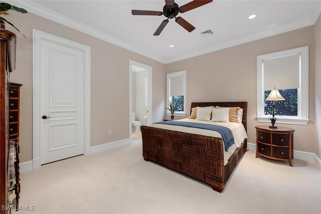 bedroom featuring ceiling fan, light colored carpet, crown molding, and ensuite bath