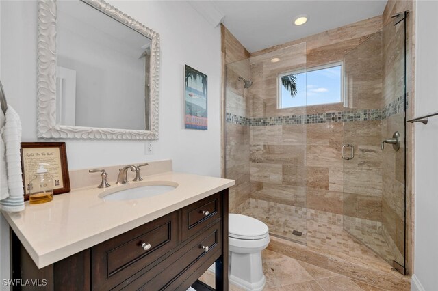 bathroom with a stall shower, vanity, toilet, and recessed lighting